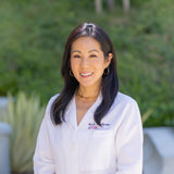 Woman in a white shirt with a logo outdoors