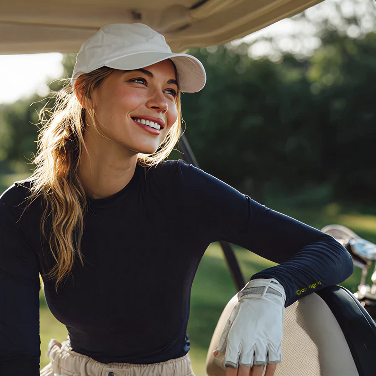 Woman in a golf cart wearing a cap and glove on a golf course