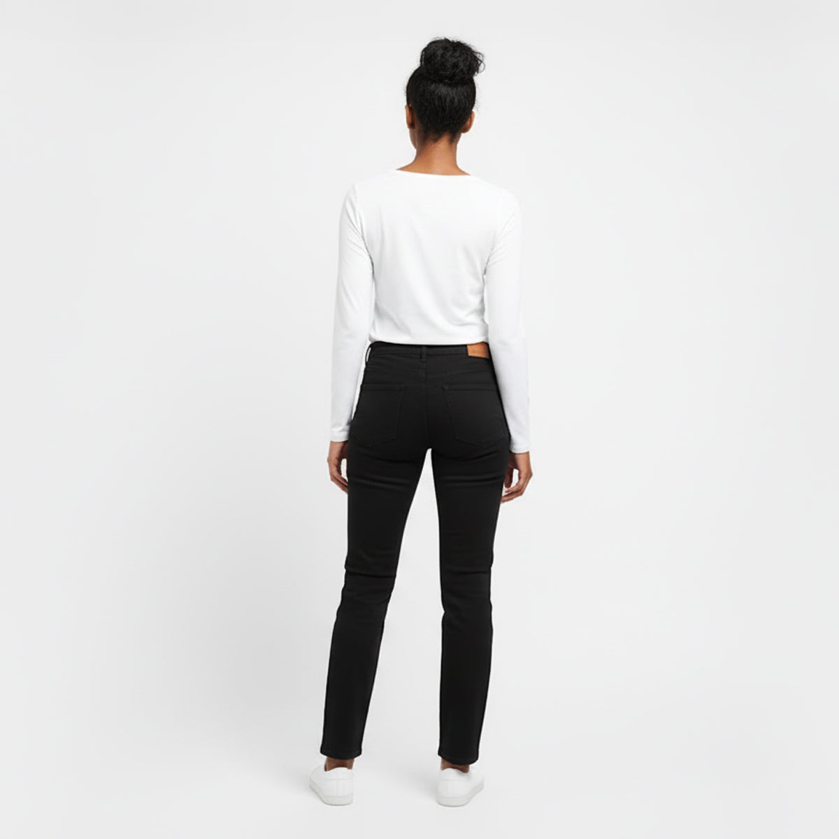 Person wearing a white long-sleeve shirt and black pants on a white background