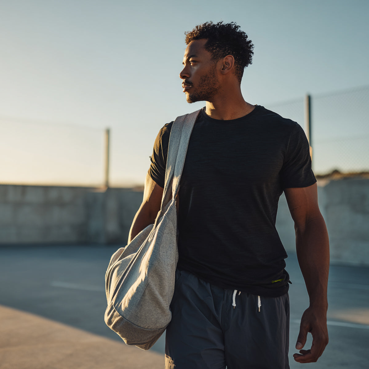 Man holding a bag on a beach at sunset