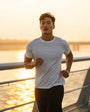 Man running on a bridge during sunset