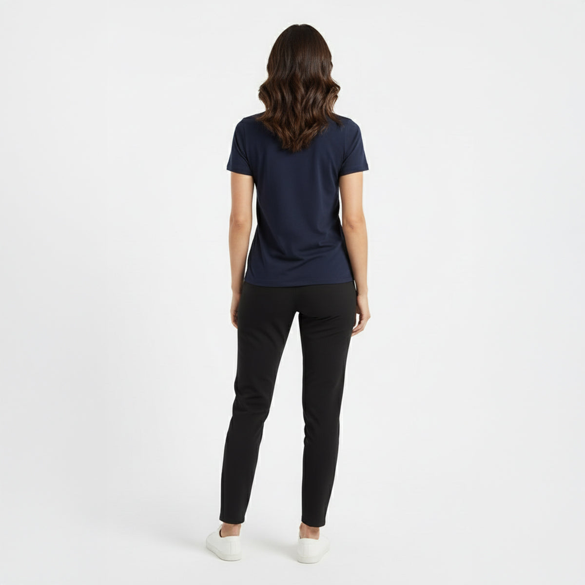 Woman wearing a navy blue t-shirt and black pants on a white background
