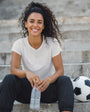Woman sitting on steps with a water bottle and soccer ball